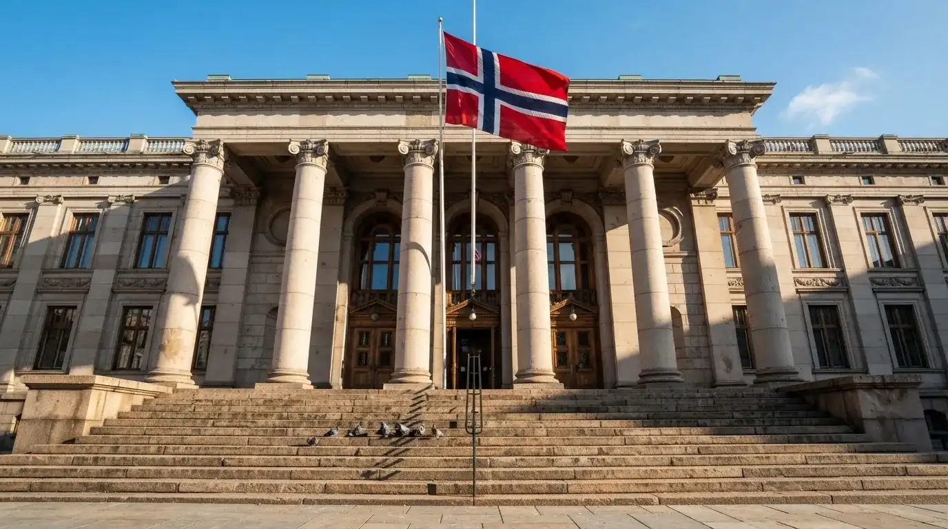 Bred granitttrapp foran en offentlig bygning med søyler og et flagg i vinden, blå himmel